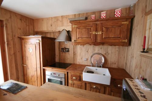 une cuisine avec des armoires en bois et un évier dans l'établissement Charming Alpine studio, à Planvillard