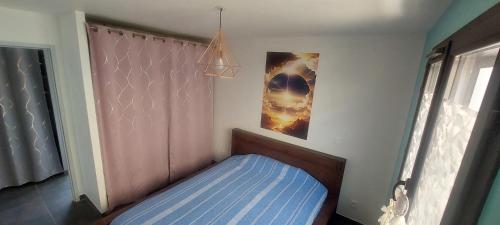 - une petite chambre avec un lit bleu et une fenêtre dans l'établissement Maison du bonheur 34570, à Saint-Paul-et-Valmalle