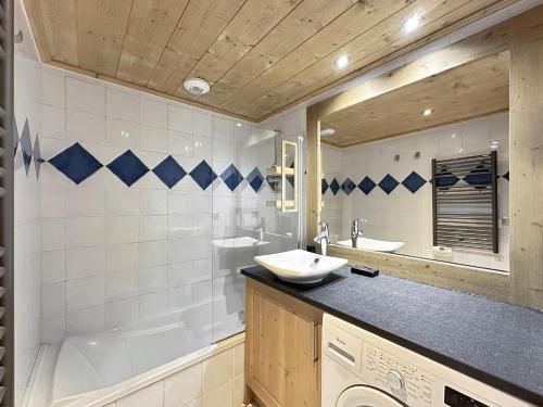 une salle de bain avec un lavabo et une machine à laver dans l'établissement ROUS02 Appartement 6 8 personnes au centre station, aux Carroz d'Arâches
