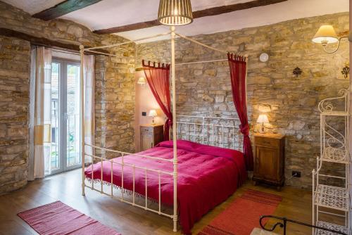 a bedroom with a canopy bed in a stone wall at La Cascina Langa in Ponti