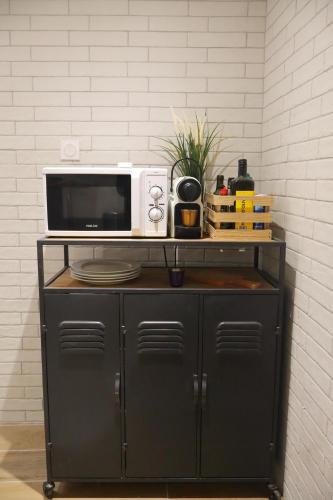 un four micro-ondes installé au-dessus d'une armoire noire dans l'établissement duplex centre historique climatisé, à Toulon