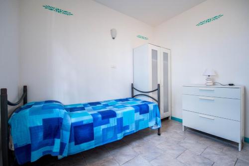 a bedroom with a blue bed and a dresser at Villaggio Residence Nettuno in Massa Lubrense