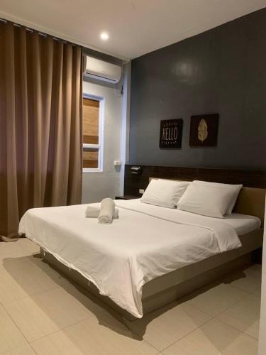 a bedroom with a large white bed in front of a window at LEUX Hotel Alona Panglao in Panglao