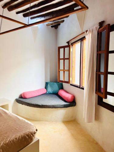 a room with a bed and two windows at Nyota ya Amani, Shela Lamu in Shela