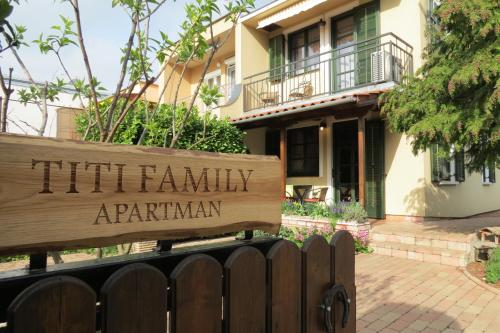 a wooden sign in front of a house at Titi Family Apartman in Bük