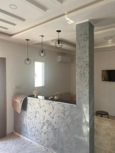 a white room with a marble counter and lights at House of djerba in Midoun