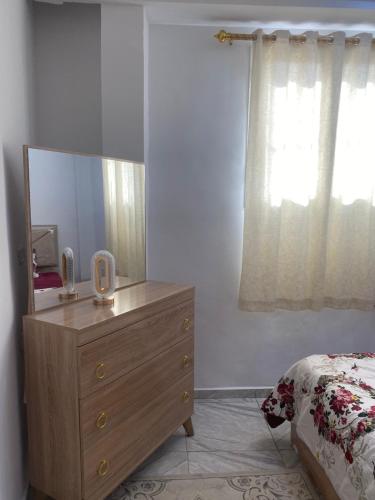 a bedroom with a dresser with a mirror and a bed at House of djerba in Midoun