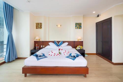 a bedroom with a bed with a flower on it at Nha Trang Lodge Hotel in Nha Trang