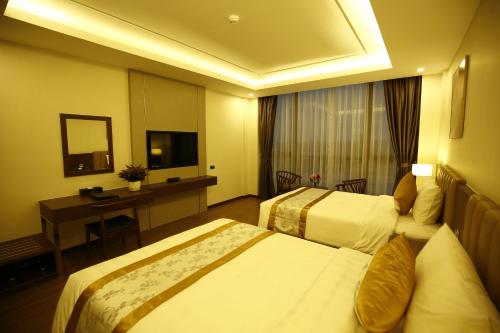 a hotel room with two beds and a desk at Songlam Waterfront Hotel - 藍江酒店 in Ha Tinh