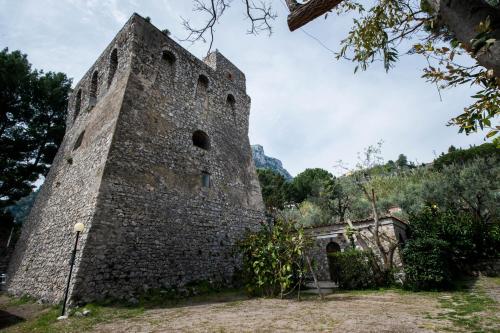 an old stone building with a tower at Villaggio Residence Nettuno in Massa Lubrense