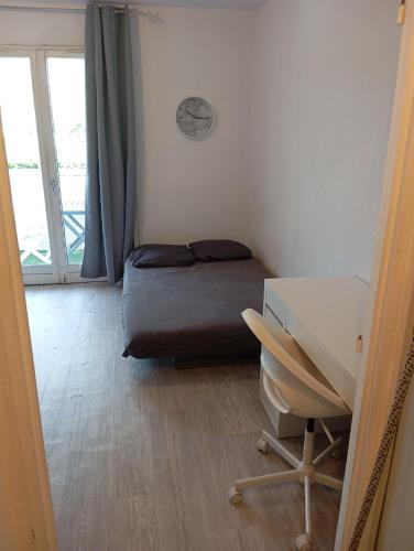 a bedroom with a bed and a desk and a window at Appartement à 5 min des plages, parking gratuit in Le Pradet