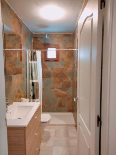 a bathroom with a toilet and a sink and a shower at LA OLA Tarifa in Tarifa