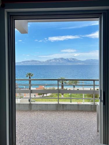 a view of the ocean through a sliding glass door at Alexandros Kalamos Hotel in Áyioi Apóstoloi