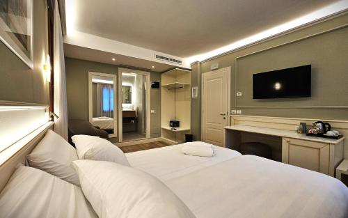 a hotel room with two beds and a television at Hotel Guerrini in Venice