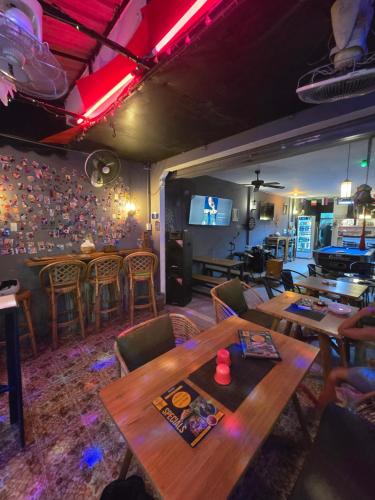 a room with tables and chairs and a television at Kata Cozy Guest Room in Kata Beach