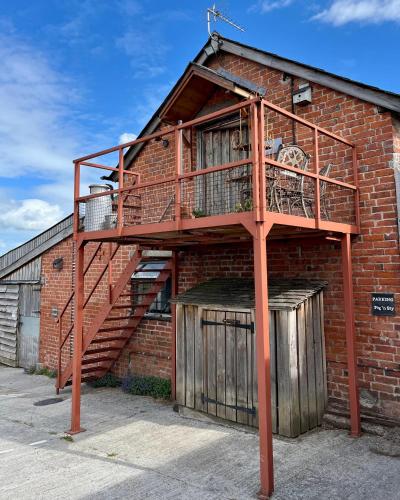 a brick building with a staircase on the side of it at The Hayloft in Hereford