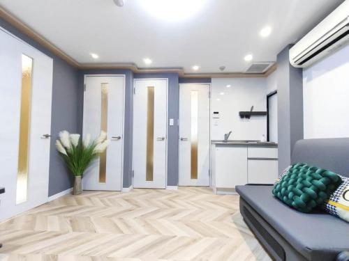 a living room with a blue couch and a kitchen at 11全新装修 2室1厅1浴室1卫生间 设施齐全 最大3人 2 rooms 1dining room 2bathrooms 2toilets Max 3P 免费无线网络 in Tokyo