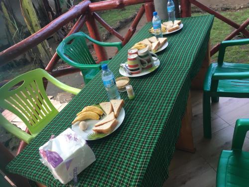 un tavolo verde con piatti di panini e bottiglie d'acqua di Humphrey home stay ad Arusha