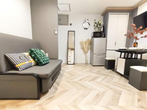a living room with a couch and a kitchen at 11全新装修 2室1厅1浴室1卫生间 设施齐全 最大3人 2 rooms 1dining room 2bathrooms 2toilets Max 3P 免费无线网络 in Tokyo