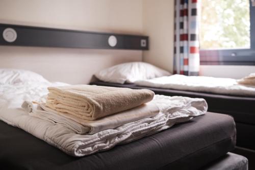 a pile of towels sitting on top of a bed at Jugendgästehaus Aasee in Münster