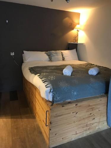 Cette chambre comprend un grand lit avec un cadre en bois. dans l'établissement Scenic fully equipped studio, à Planvillard