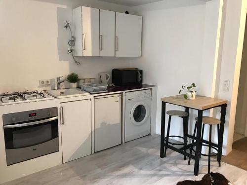 une cuisine avec des armoires blanches et une table avec un micro-ondes dans l'établissement Scenic fully equipped studio, à Planvillard