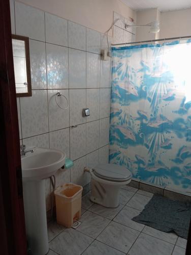een badkamer met toilet en douchegordijn bij Departamentos céntrico Las Guayabas in Puerto Iguazú