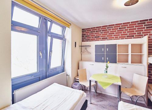 a room with a bed and a table with chairs at Jugendgästehaus Aasee in Münster