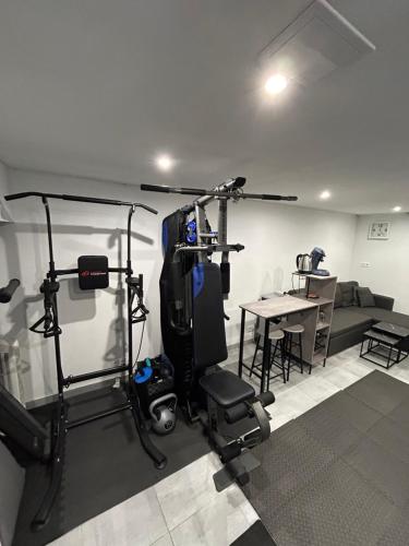 une pièce avec une salle de sport avec un canapé et une table dans l'établissement Studio sport jacuzzi, à Dijon