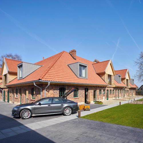 a car parked in front of a house at meinwolfsburg hotel auf dem rittergut vormals Yard Boarding Hotel in Wolfsburg