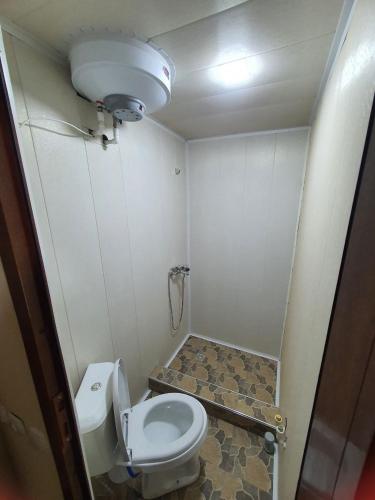 a small bathroom with a toilet and a sink at Muslima Guest House in Muruntau