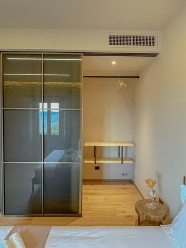 a bedroom with a large glass closet and a bed at Evoluzioni - Agriturismo in Prunetto