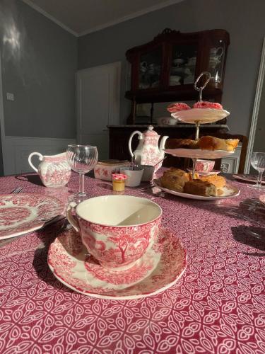 ein Tisch mit Tischdecke, Teetasse und Tellern in der Unterkunft Relais Golf et Champagne in Villers-Agron-Aiguizy