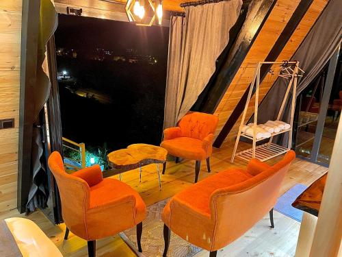 a room with orange chairs and a large window at Mirana Bungalov in Ardeşen