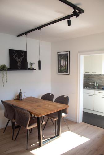 a dining room with a wooden table and chairs at Direkt am See Winterberg Elkeringhausen in Winterberg