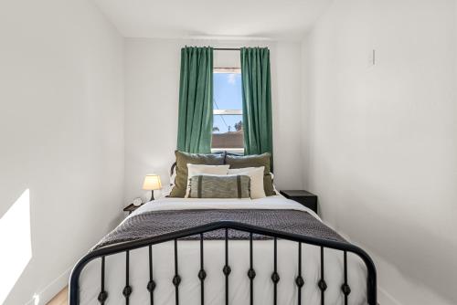 a bedroom with a bed with green curtains and a window at Perfect 2BR Near Universal Studios By Poshguest in San Fernando