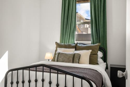 a bedroom with a bed with green curtains and a window at Perfect 2BR Near Universal Studios By Poshguest in San Fernando