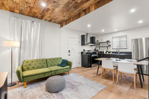a living room with a green couch and a kitchen at Perfect 2BR Near Universal Studios By Poshguest in San Fernando