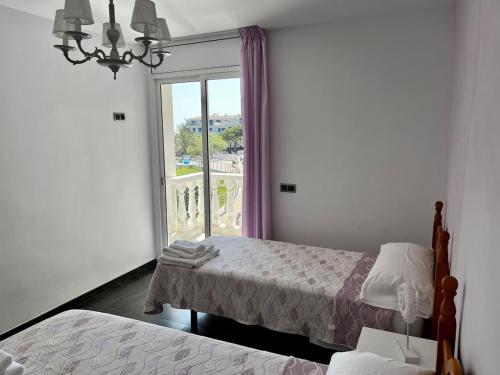 a bedroom with two beds and a large window at Mirador mar in L'Ametlla de Mar