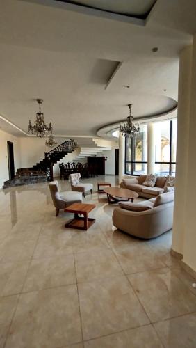 a large living room with couches and tables at منتجع وفيلا تل الرمان in Ar Rummān