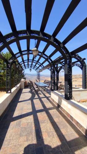 a patio with a table and benches on a bridge at منتجع وفيلا تل الرمان in Ar Rummān