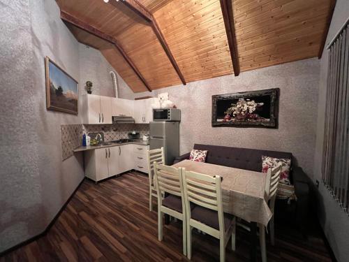 a kitchen and dining room with a table and chairs at Shahdag Suvacal House in Qusar