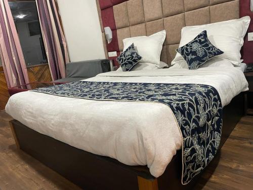 a bed with a blue and white blanket and pillows at Hotel Senorita in Jāmb