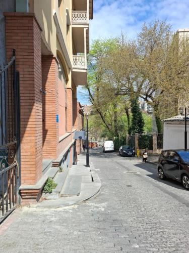 an empty street with cars parked on the side of a building at Aura Plaza Hotel in Tbilisi City
