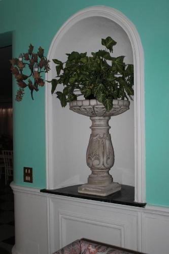 a vase sitting on a table with a plant in it at Palazzo Scavone in Palermo