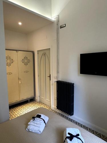 Habitación con 2 toallas y TV en la pared en La Dimora Di Teresa, en Lanciano