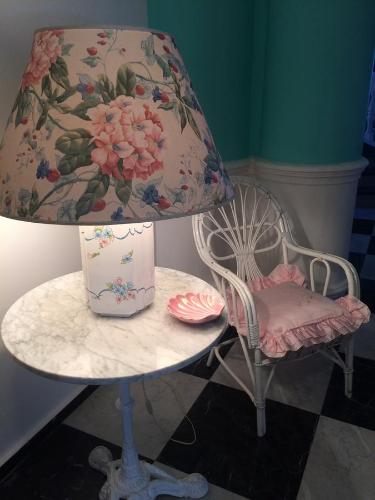 a table with a lamp and a chair and a table with a lampurrection at Palazzo Scavone in Palermo