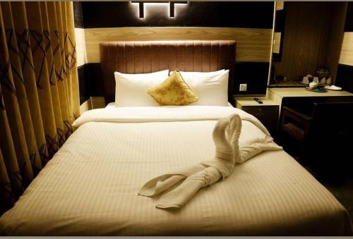 a hotel room with a large bed with a towel on it at Garden View Villa in Rājshāhi