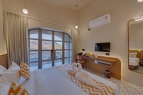 a hotel room with a bed and a balcony at Villa Euphoria Resort at Statue of Unity in Navgam