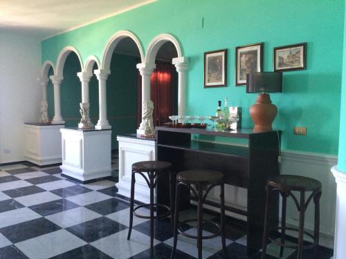 a bar with stools in a room with green walls at Palazzo Scavone in Palermo